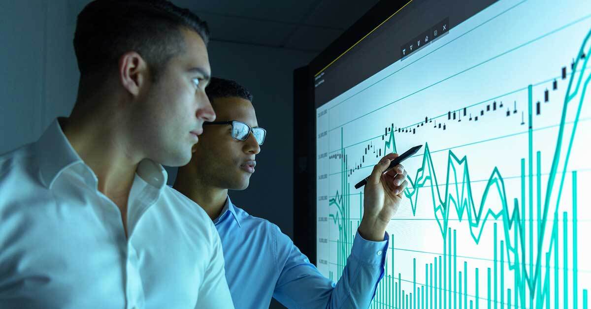 Data analytics constant working with a business stakeholder looking at a line graph report.